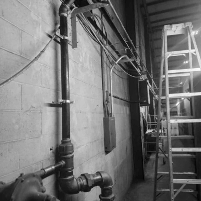 installed plumbing in a basement, black and white image